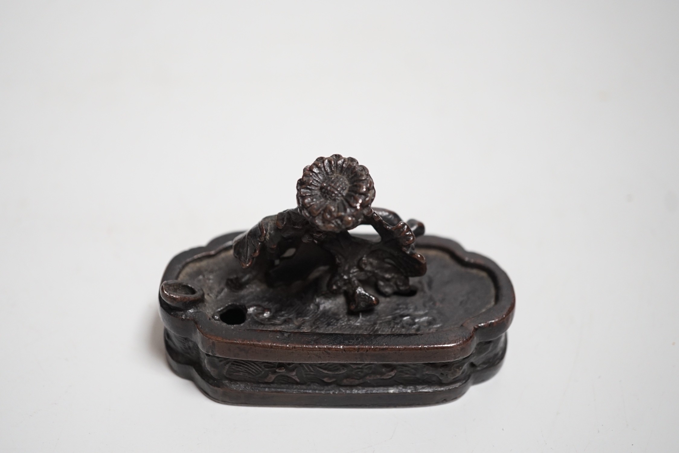 A Chinese bronze water-dropper of a flowering shrub in a jardiniere, 17th/18th century, 8cms wide